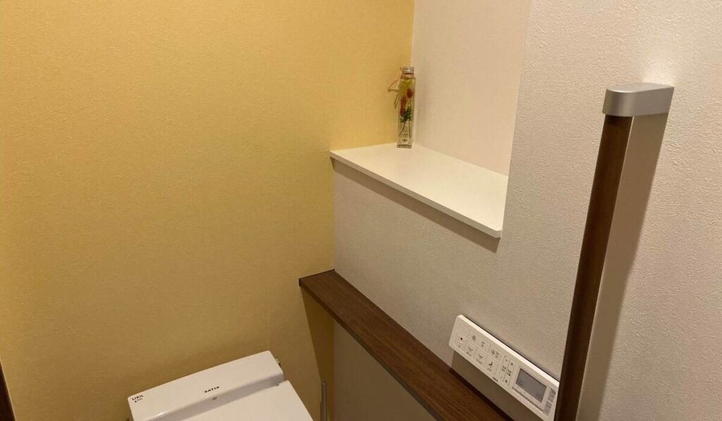 ポップな黄色のアクセントクロスのトイレの写真