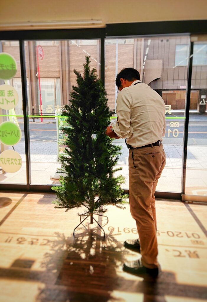 クリスマスツリーをセッティングする社長